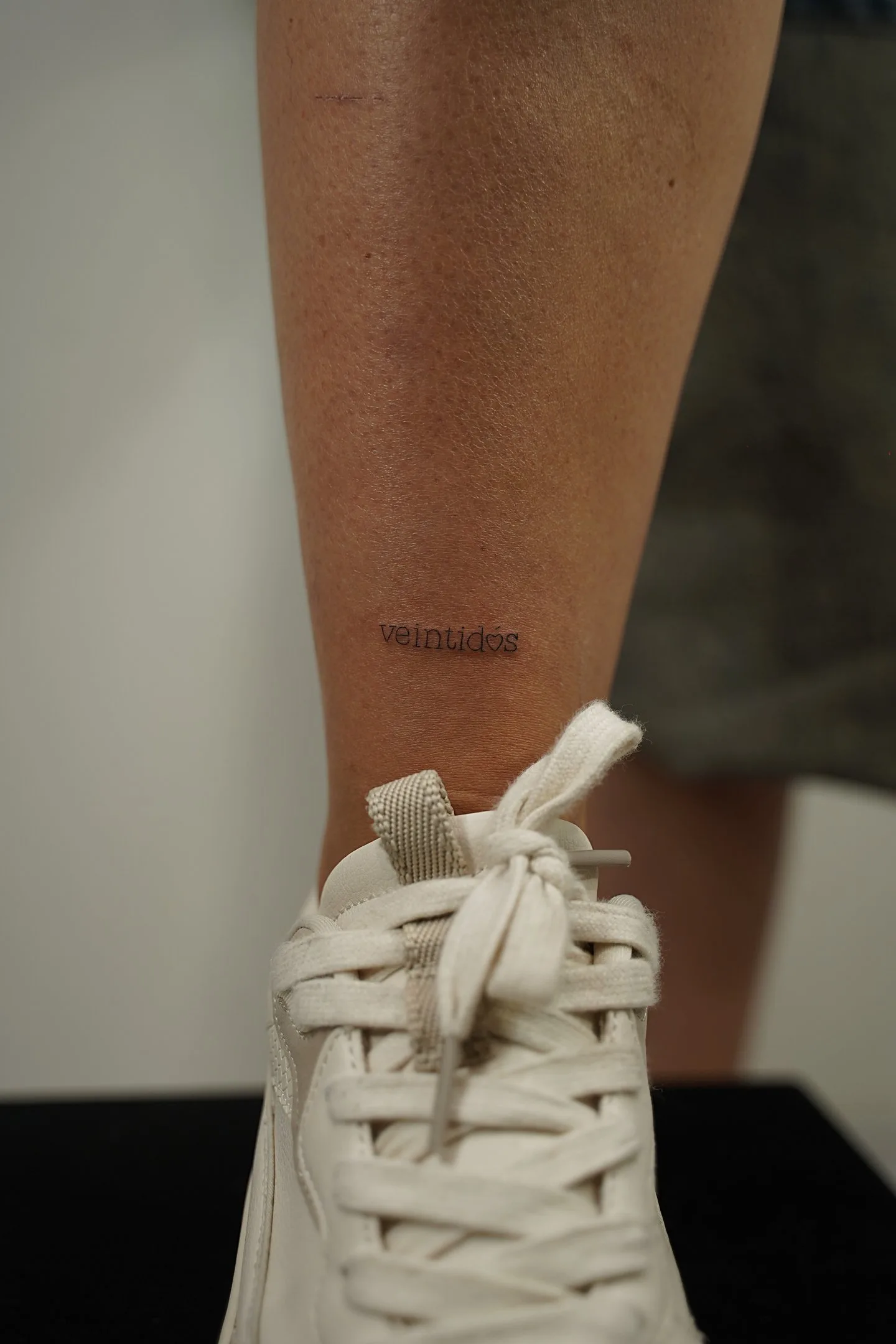Tatuaje fineline texto veintidós en tobillo madrid