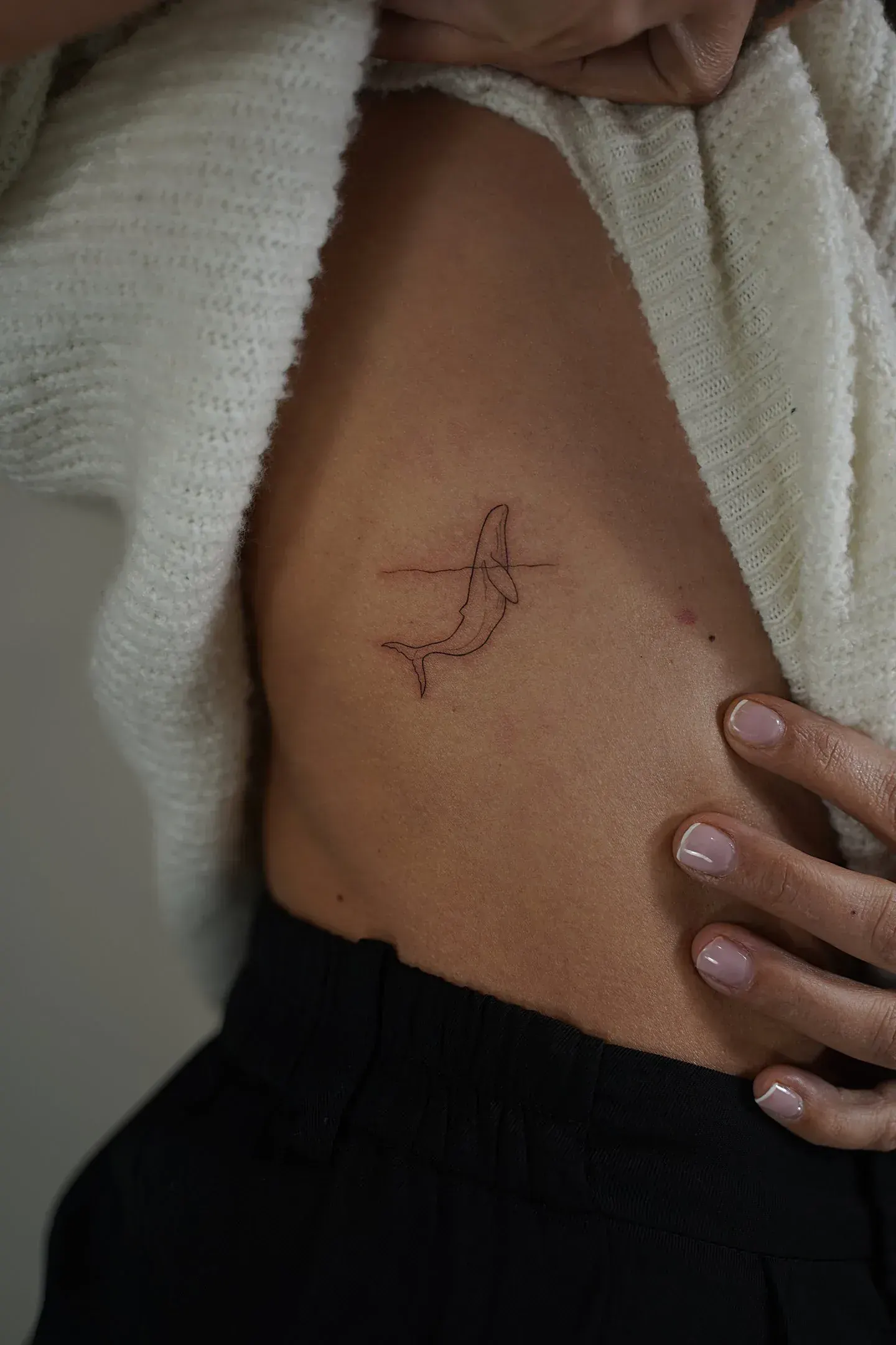 Tatuaje fineline ballena minimalista en una línea en costado madrid