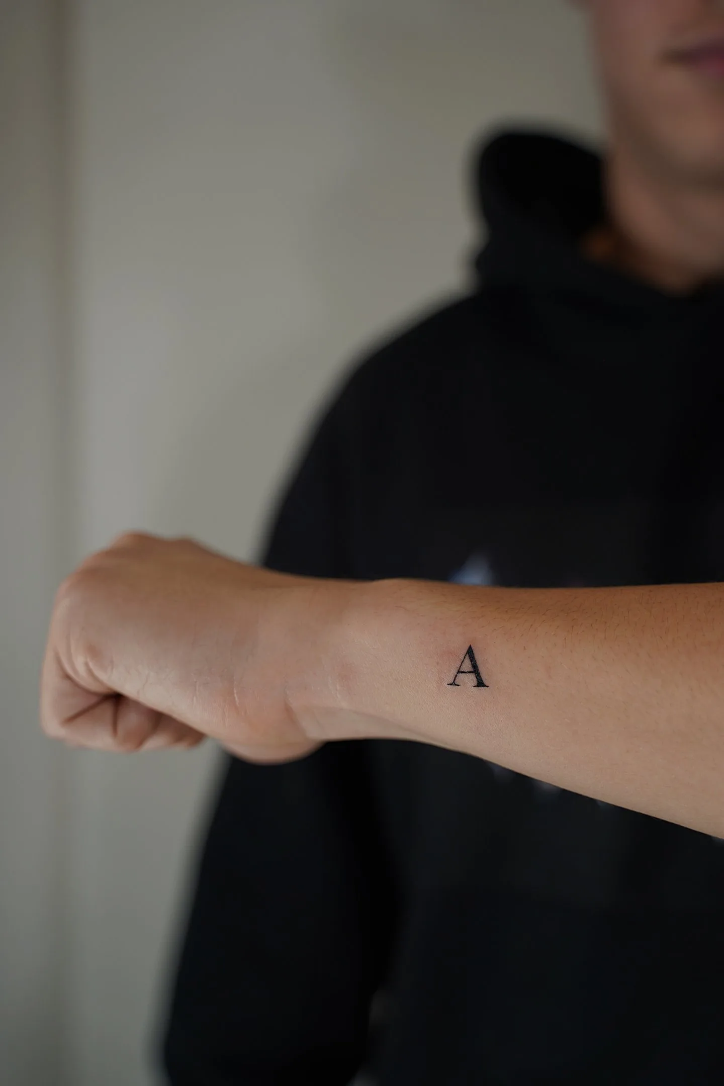Tatuaje fineline letra A minimalista en muñeca madrid
