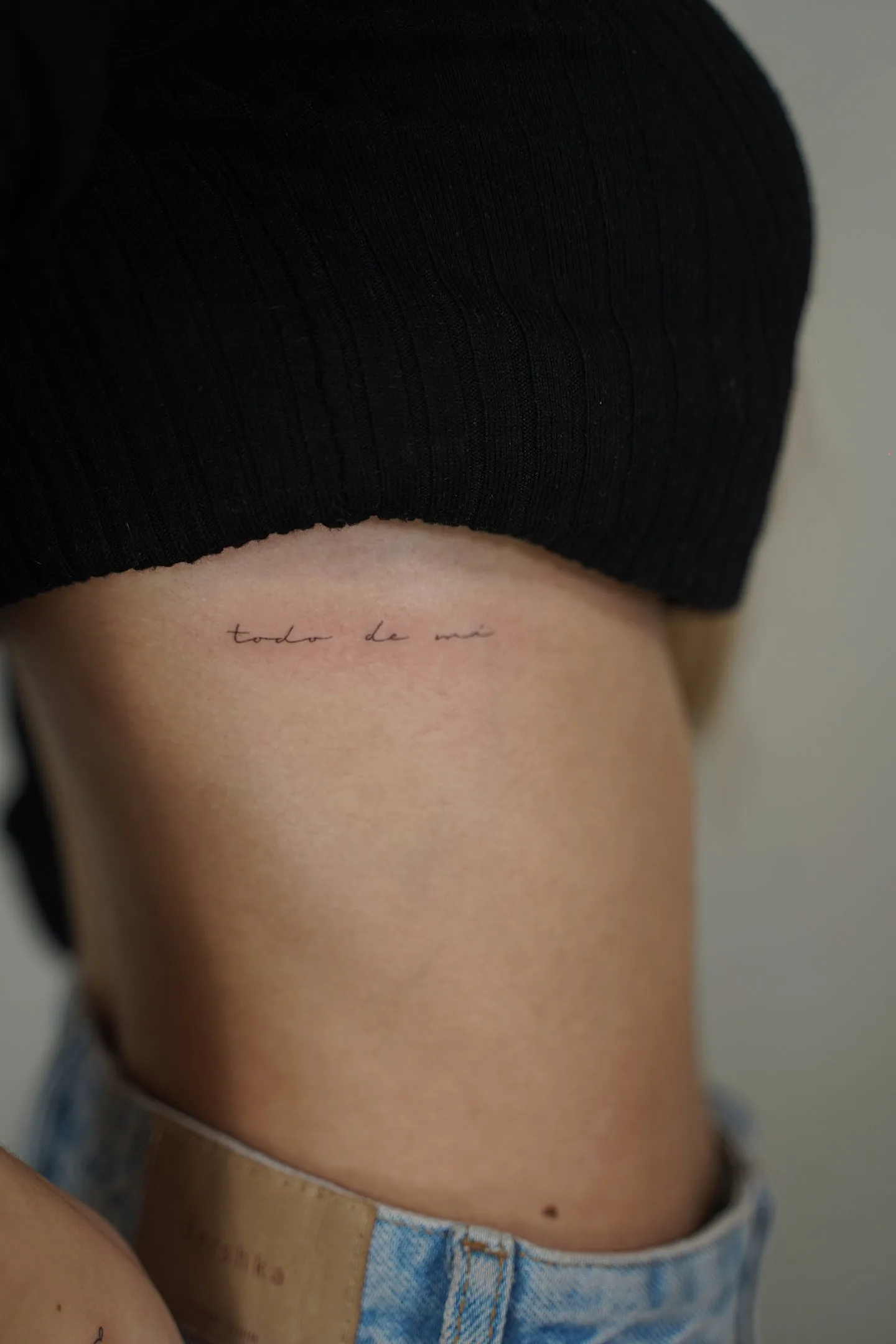 Tatuaje fineline frase todo de mí en cursiva en costado madrid