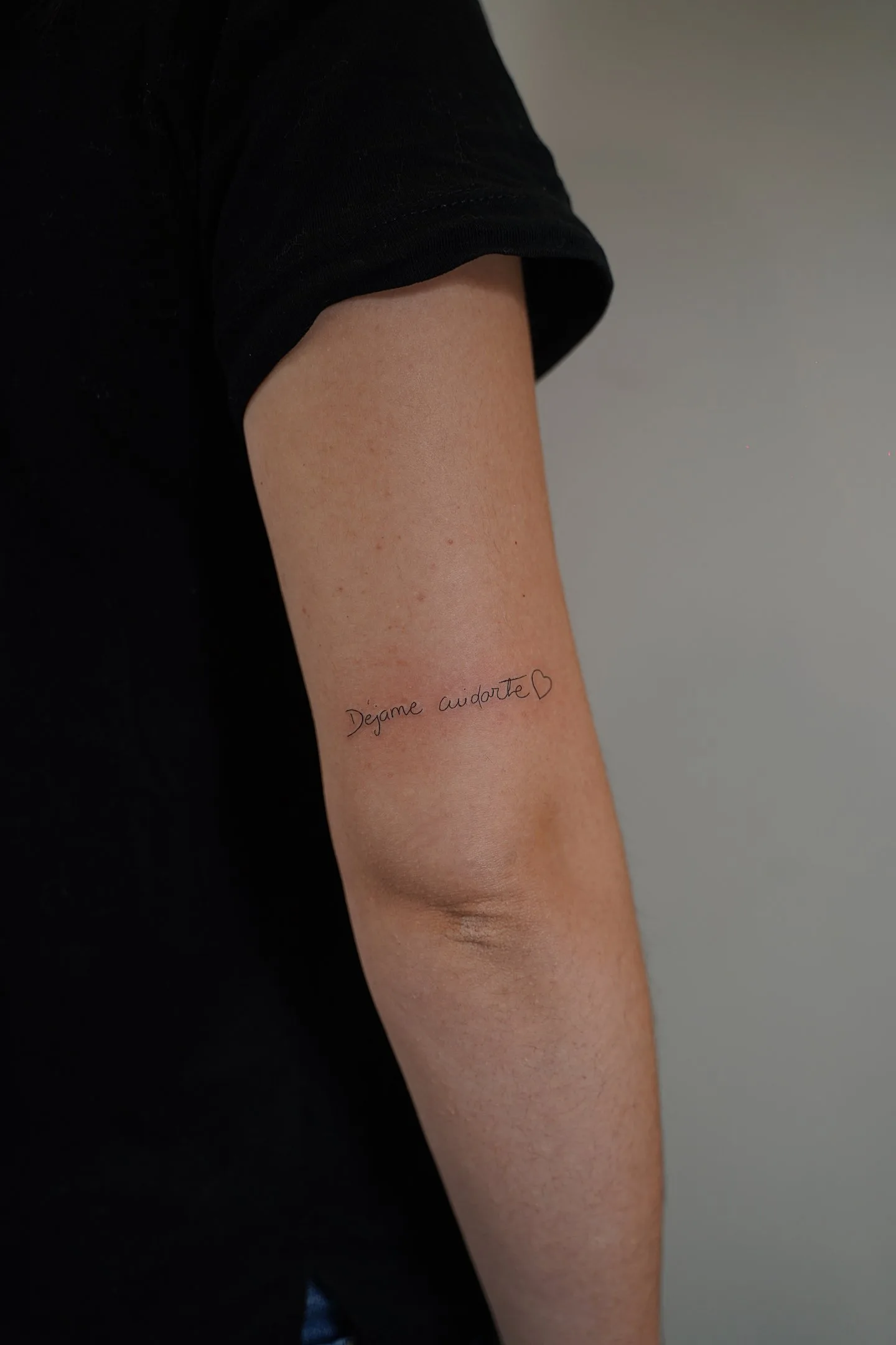 Tatuaje fineline frase déjame cuidarte con corazón en brazo madrid