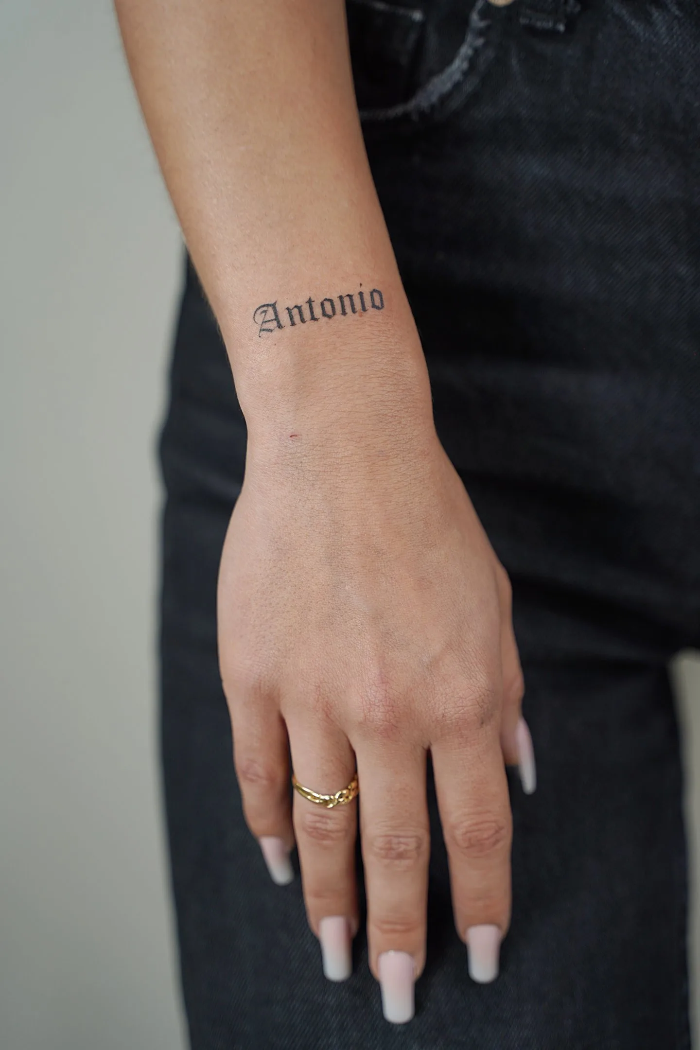 56) “Antonio” en tipografía grueso-fino en la muñeca