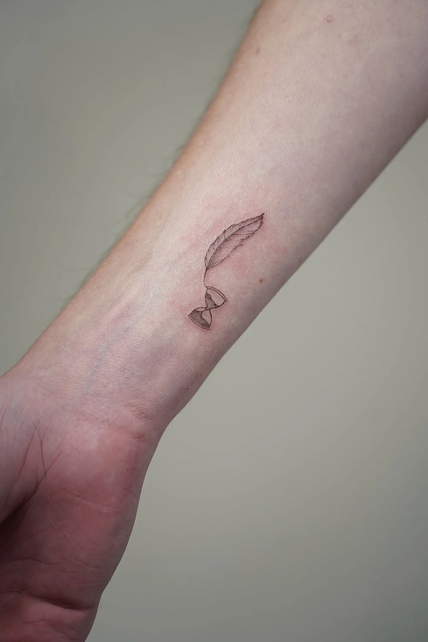 94) Reloj de arena con pluma