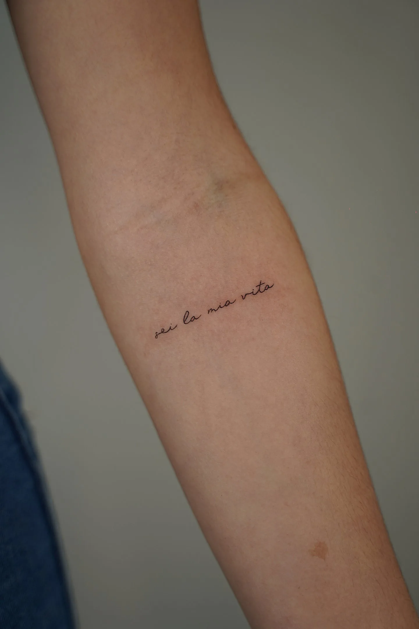 41) “sei la mia vita” en minúsculas en el antebrazo