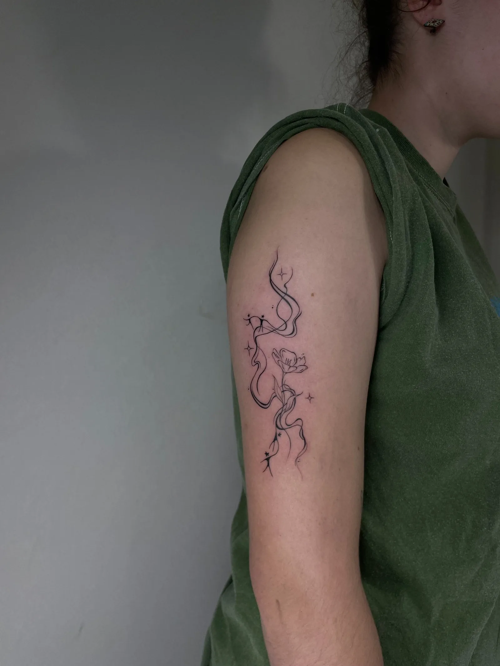 8) Composición con líneas fluidas, flor y estrellas en el brazo