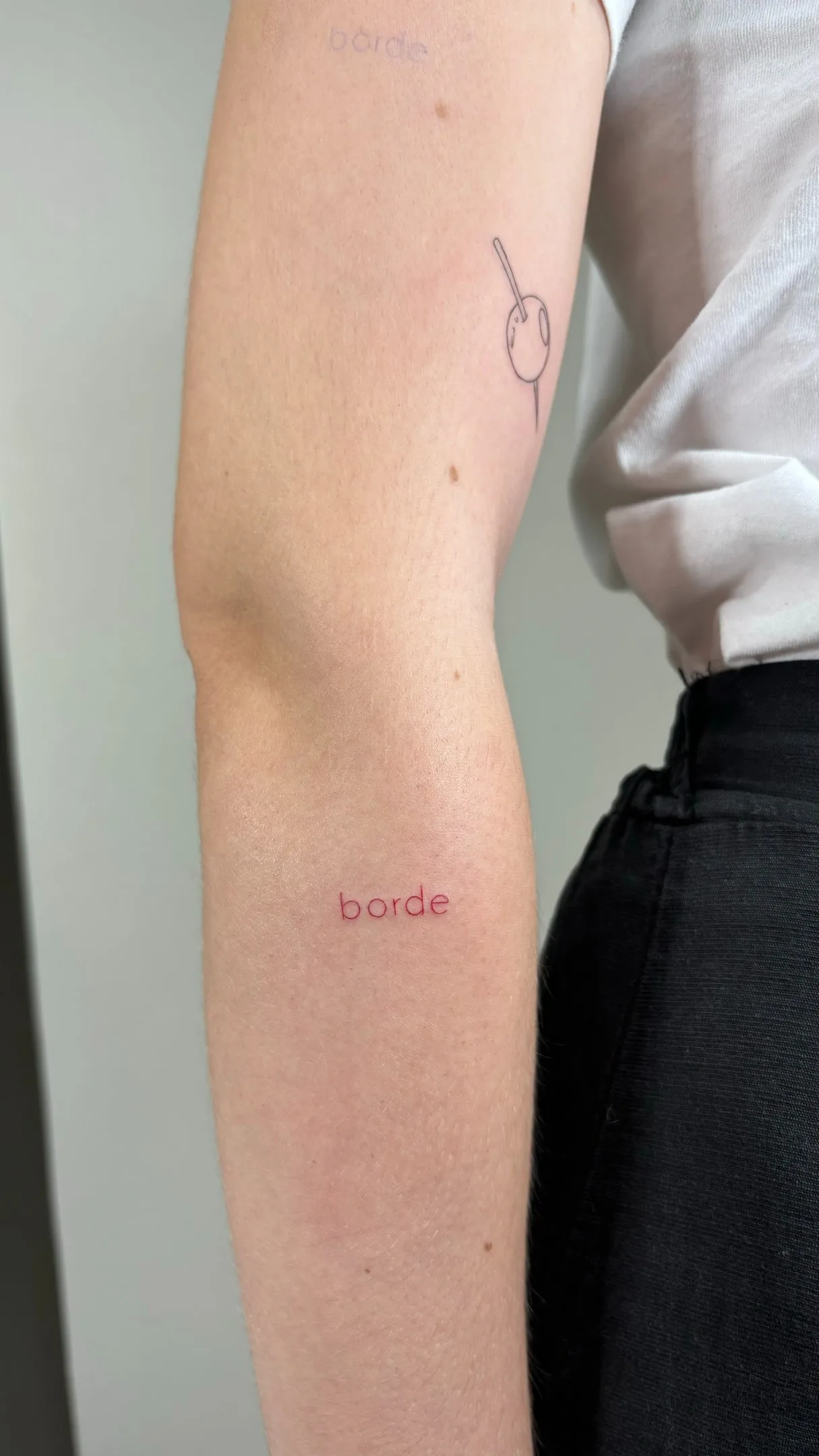 36) "Borde" en tinta roja en el antebrazo