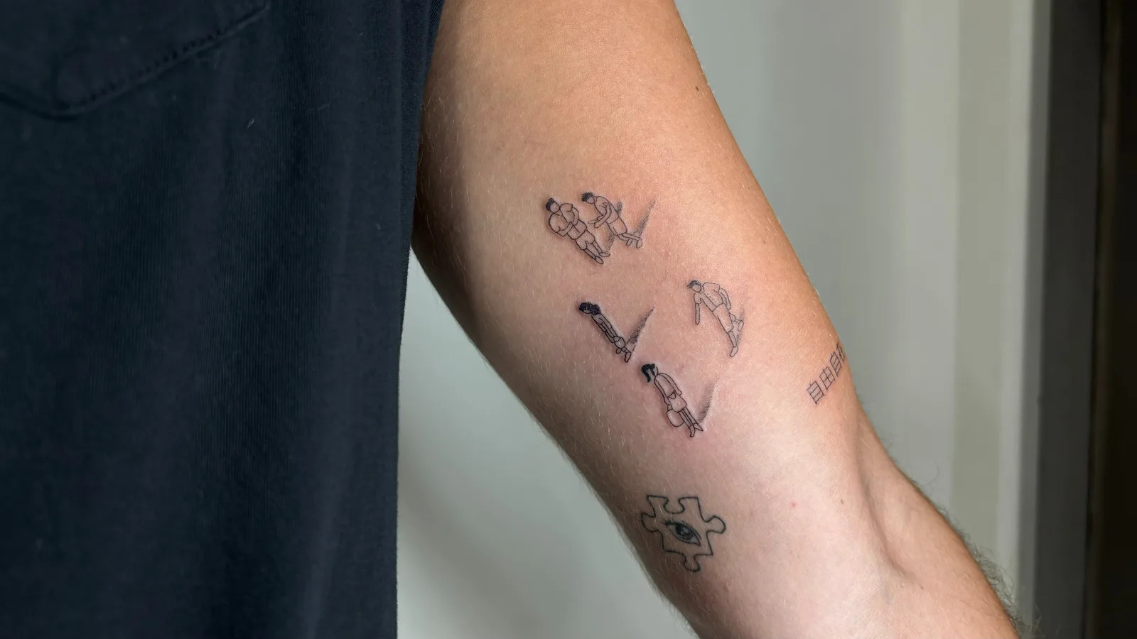 40) Composición de figuras, kanji y pieza de puzzle en el antebrazo
