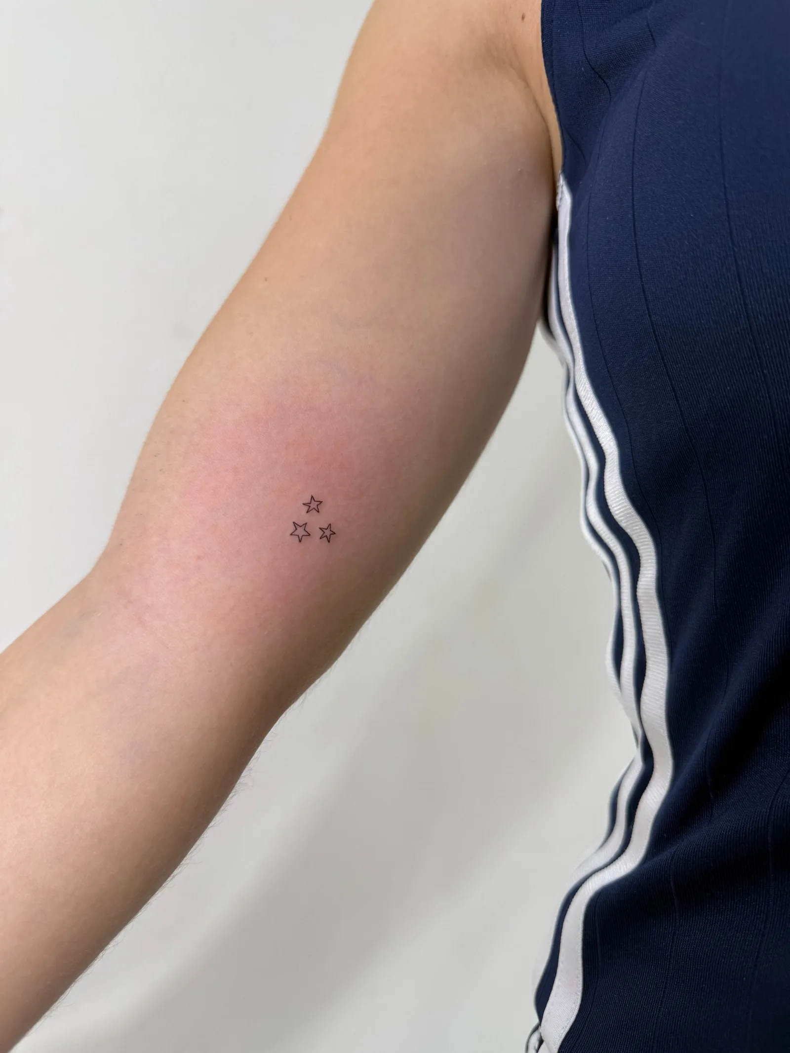 47) Tres estrellas en contorno en el brazo