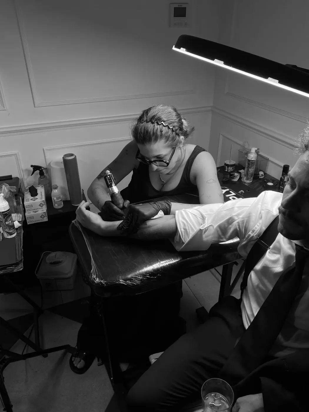 Tatuadora de Sinkply haciendo un tatuaje fine line a un invitado en una boda en Madrid