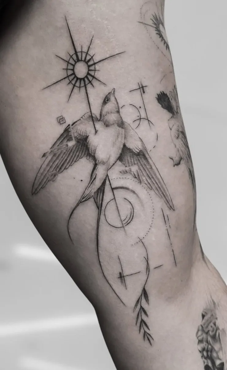 Tatuaje microrealismo geométrico pájaro con sol radial estrellas y rama de olivo madrid