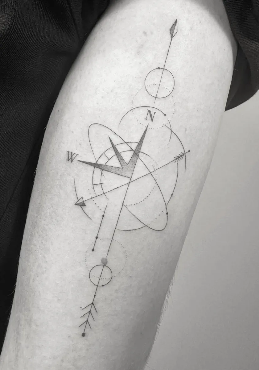 Tatuaje microrealismo geométrico brújula minimalista con órbitas y flechas madrid