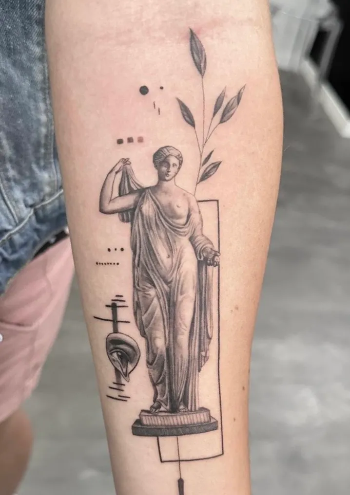 Tatuaje microrealismo geométrico Venus clásica con rama botánica en antebrazo madrid