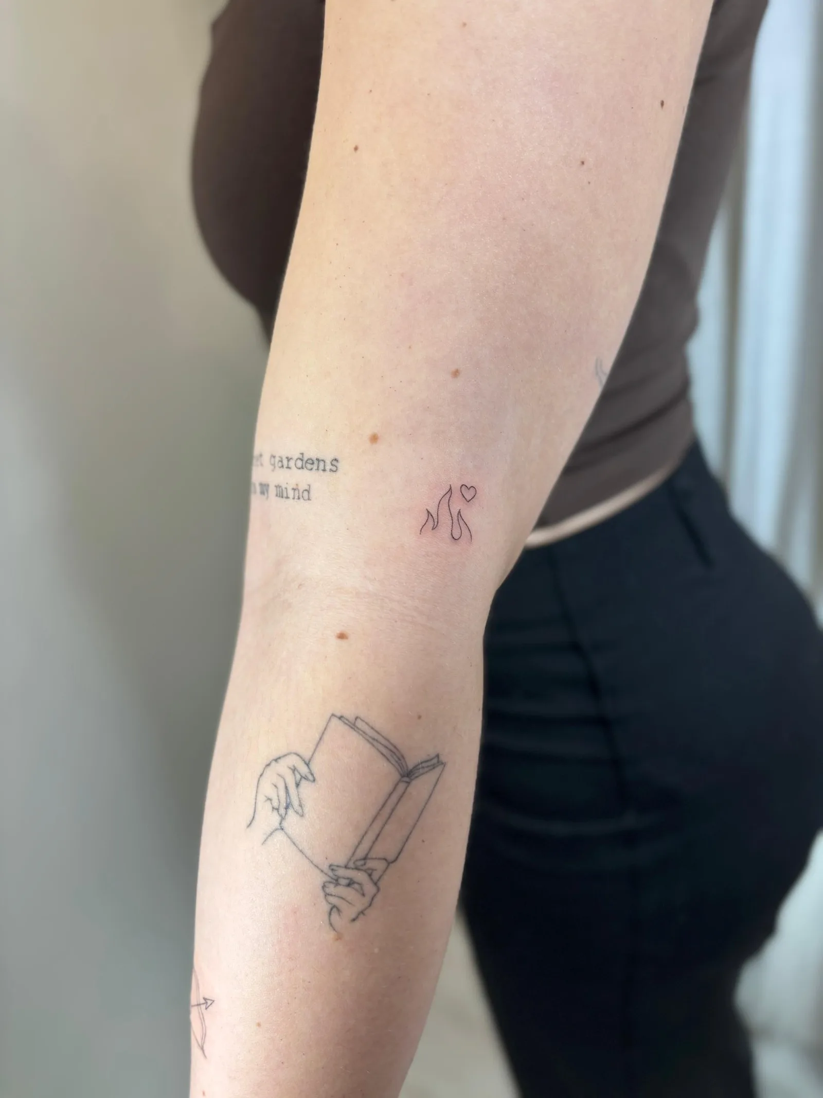 Fine line tattoo Madrid — gardens in my mind phrase with abstract cats and heart