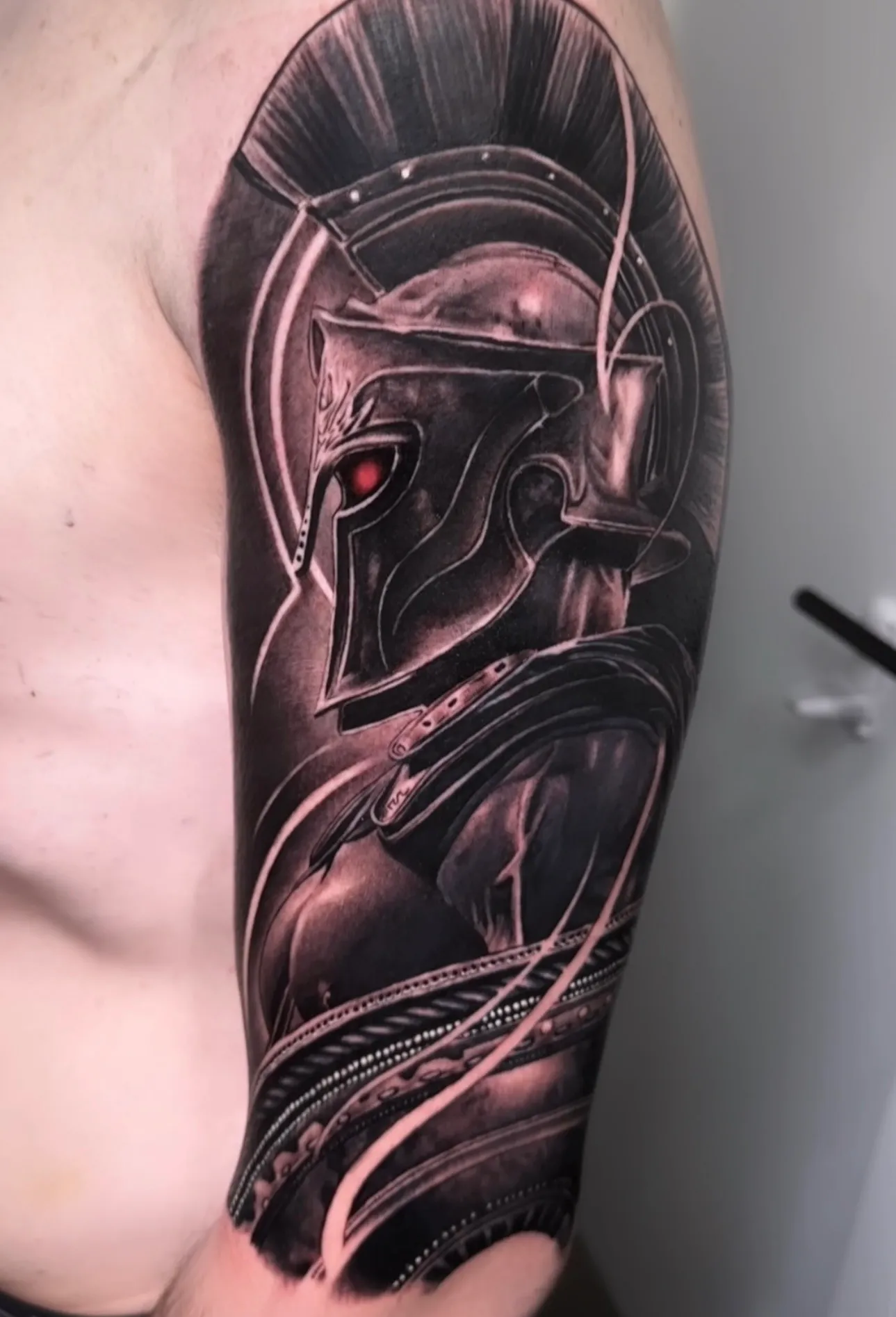 Tatuaje realismo casco espartano con penacho y ojo iluminado madrid