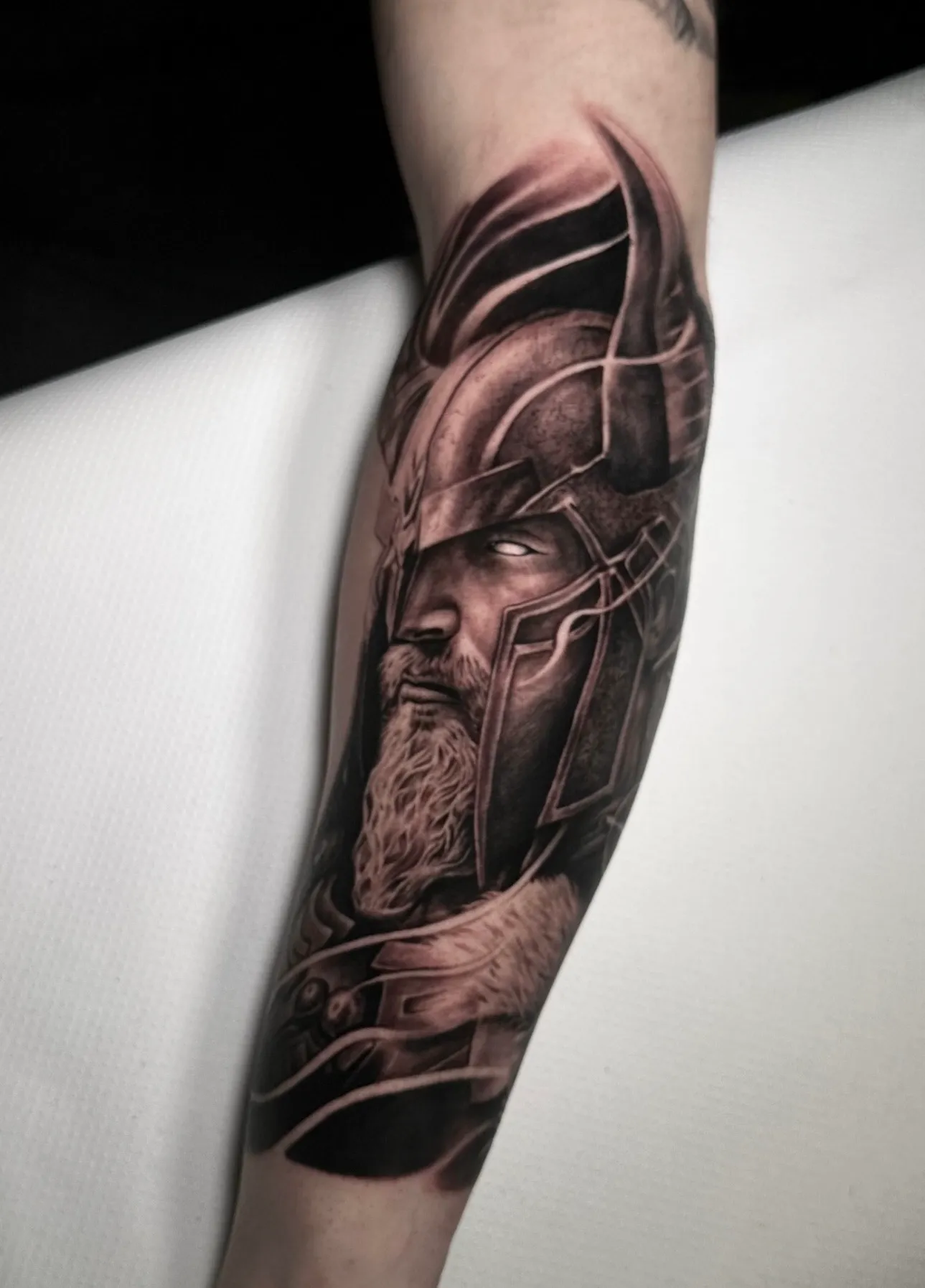 Tatuaje realismo guerrero vikingo barbudo con casco con cuernos en antebrazo madrid