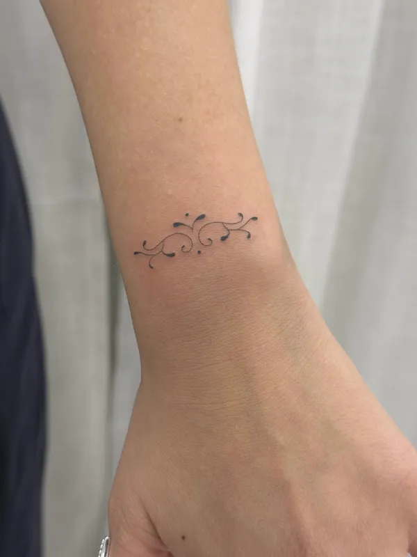 Tatuaje ornamental fine line en la muñeca, por Oriana en Sinkply Madrid