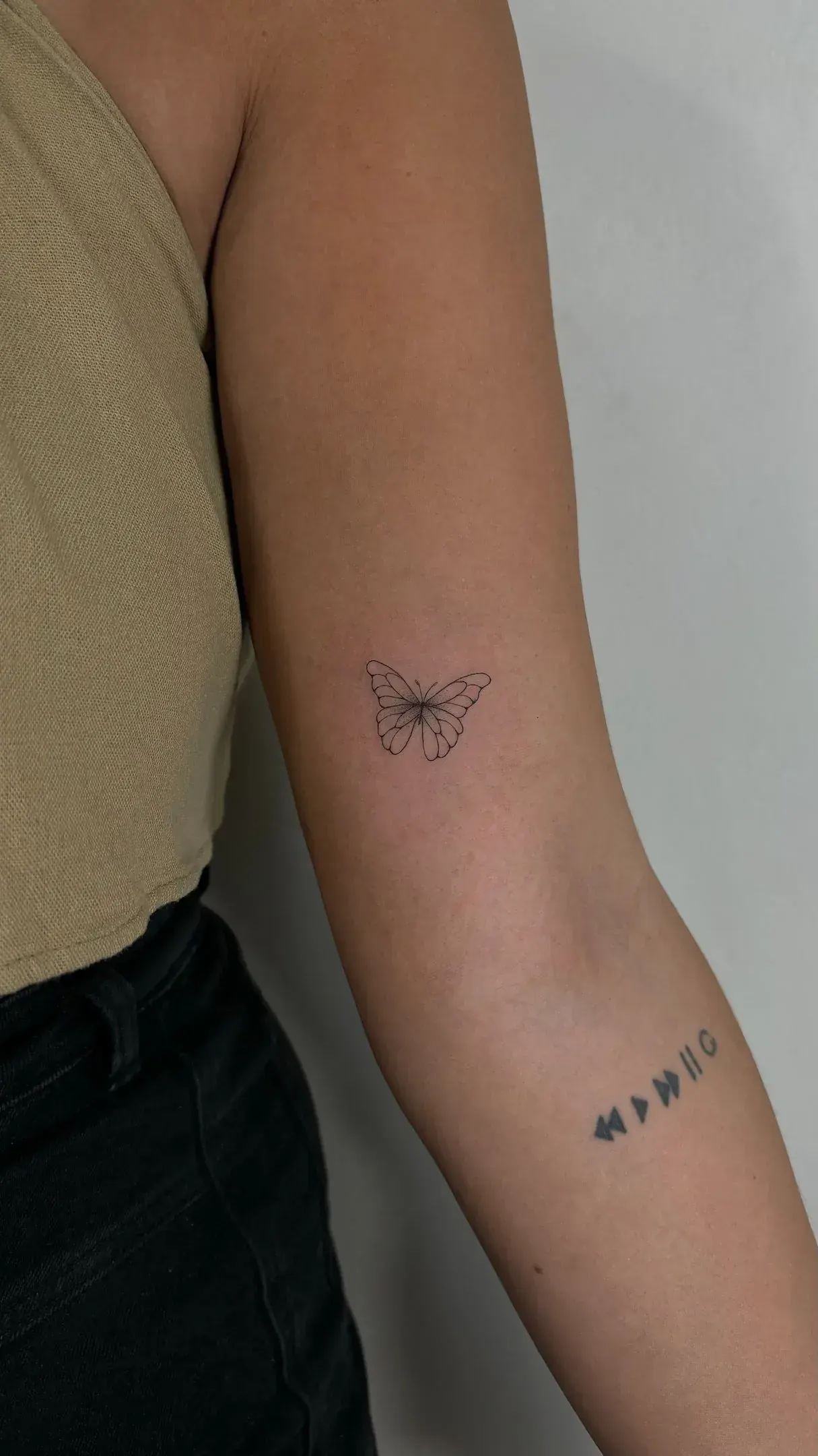 Minimalist lettering tattoo with short English phrase on inner arm