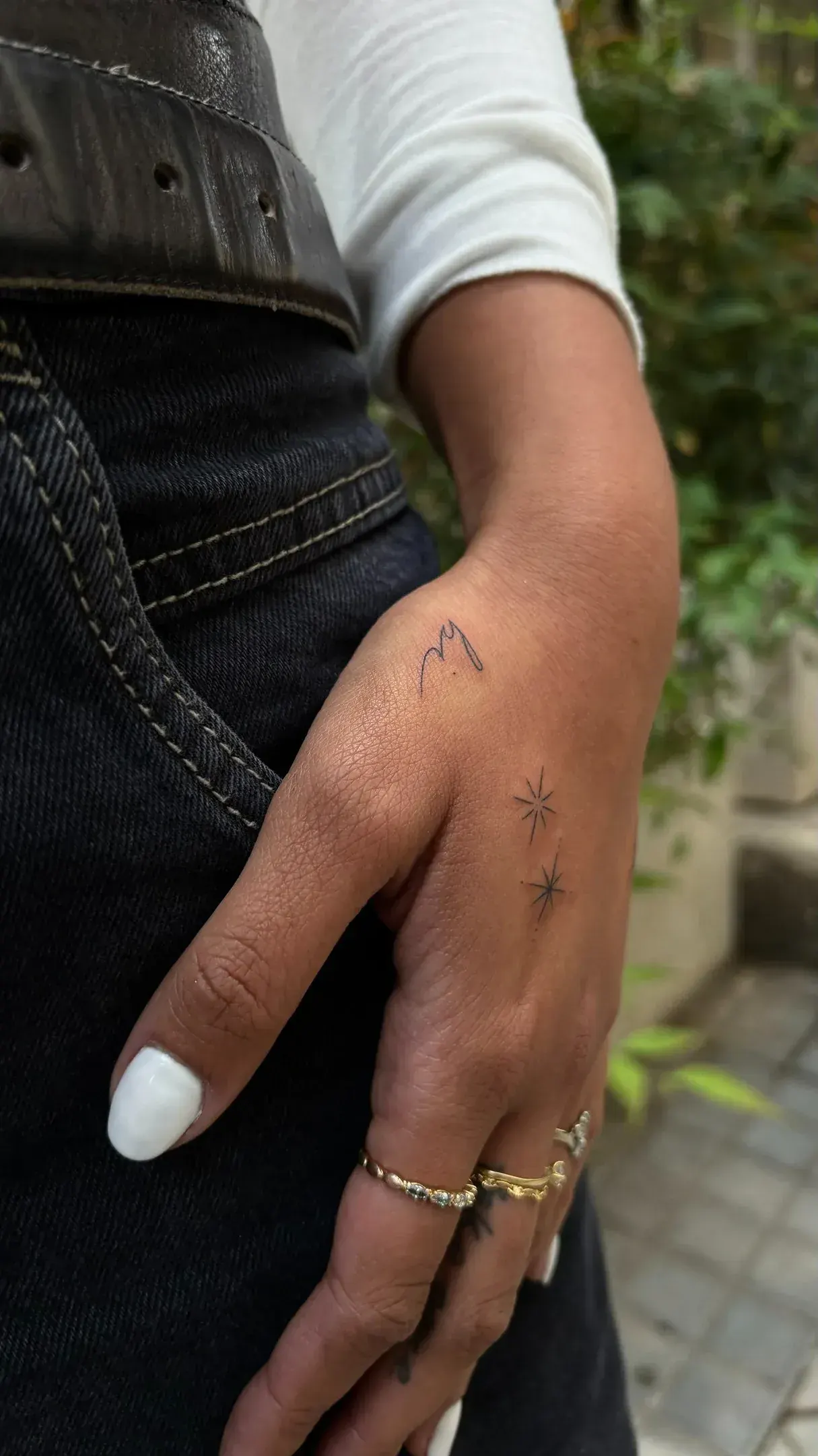 Tiny sun and moon fine line tattoo on wrist, popular tourist design