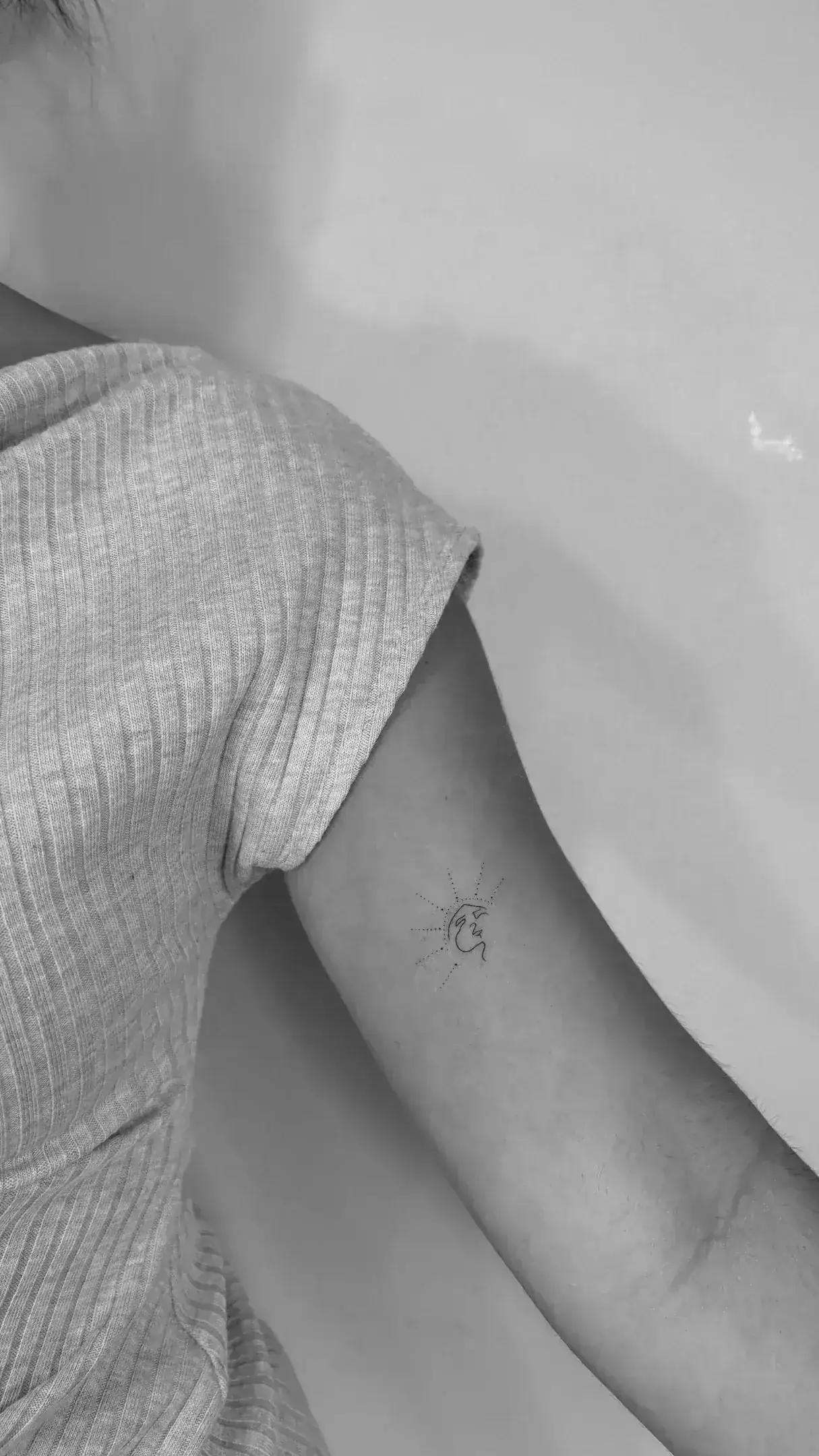 Roman numeral travel date in thin serif typography on forearm