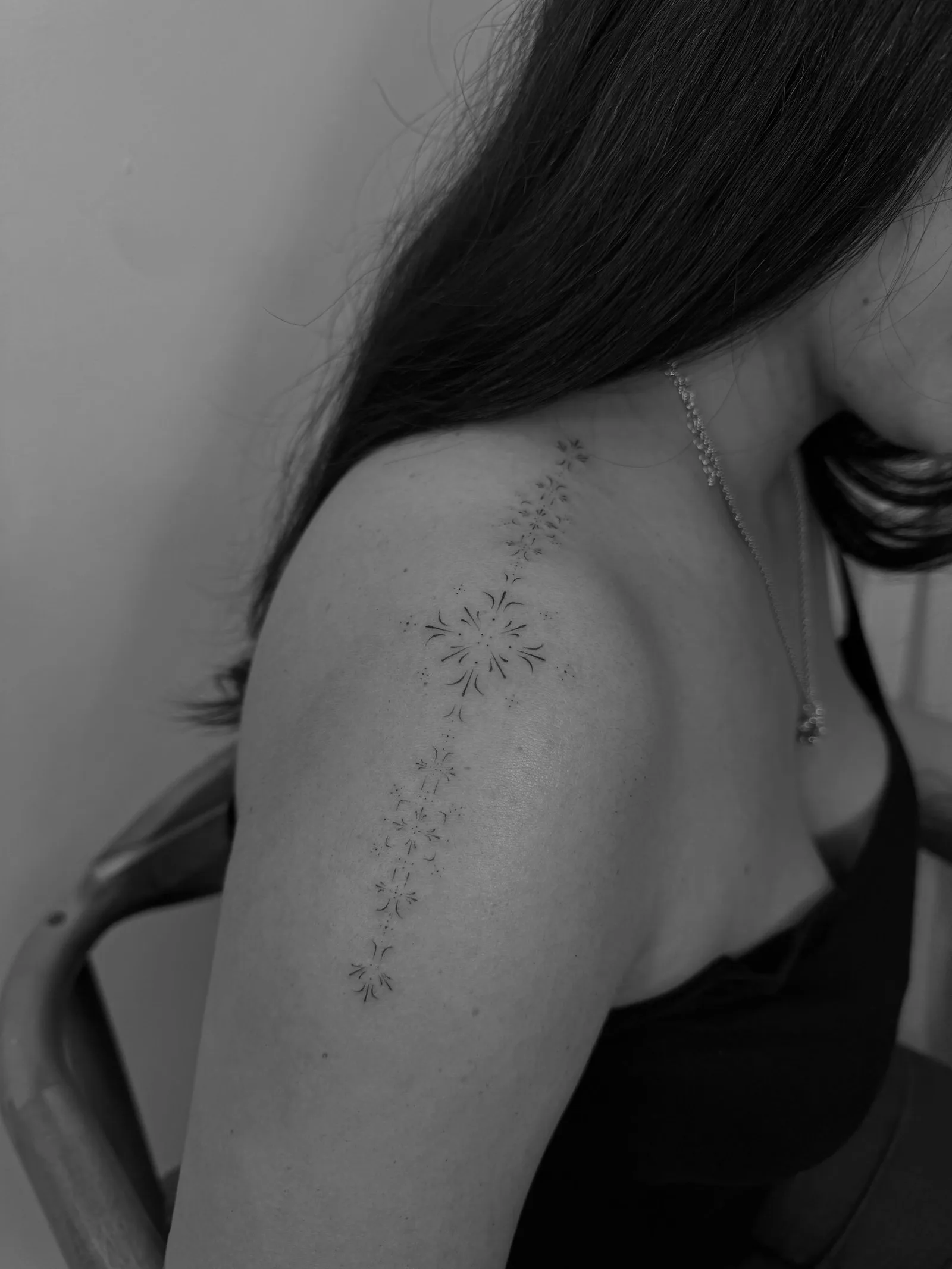 Thin script word tattoo behind the ear in fine line