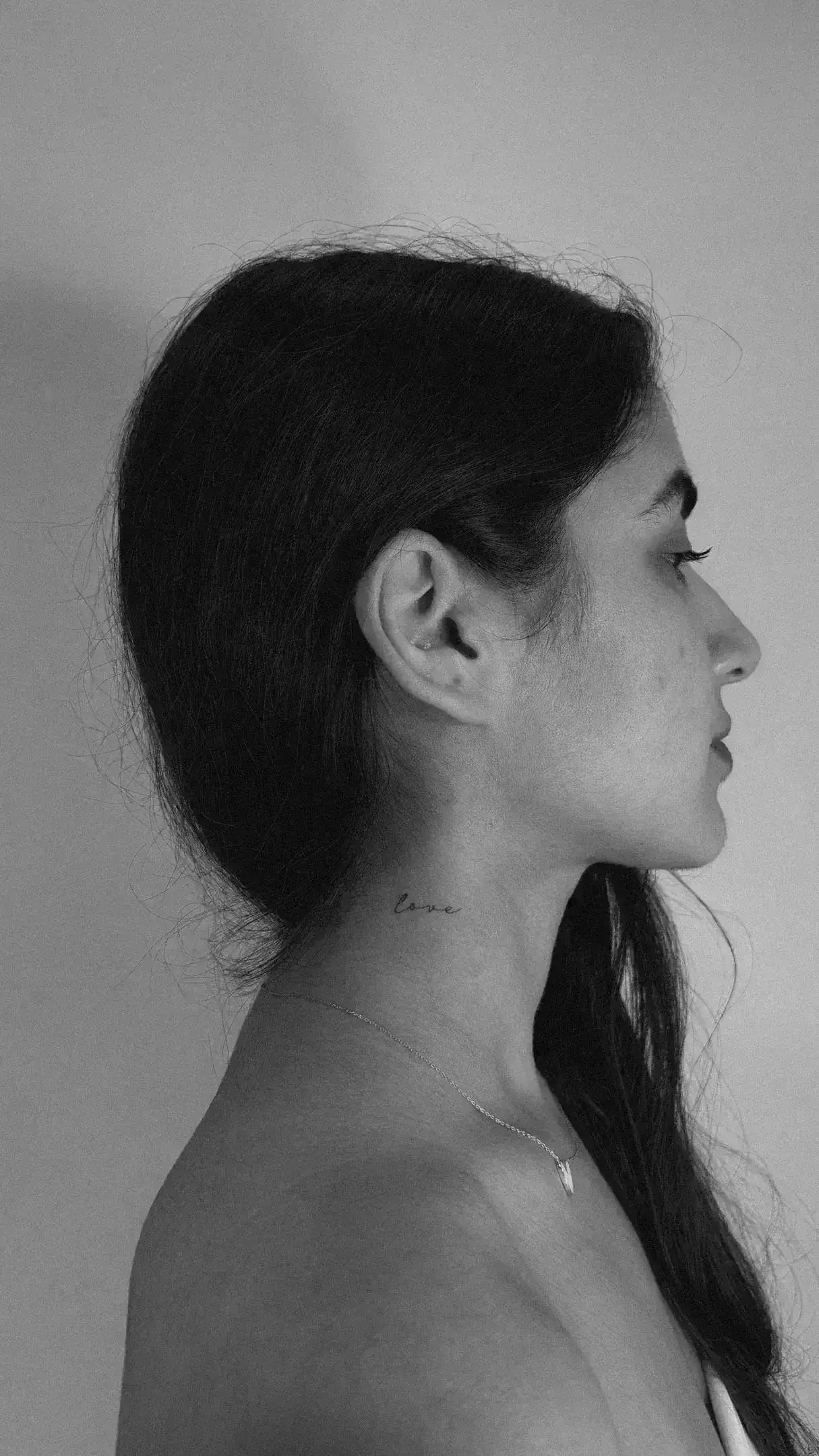 Small bird in flight tattooed in minimalist fine line on forearm
