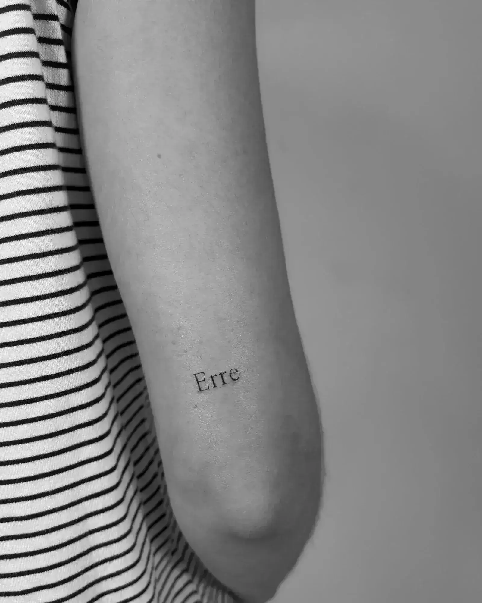 Geometric triangle with thin lines tattooed on upper arm