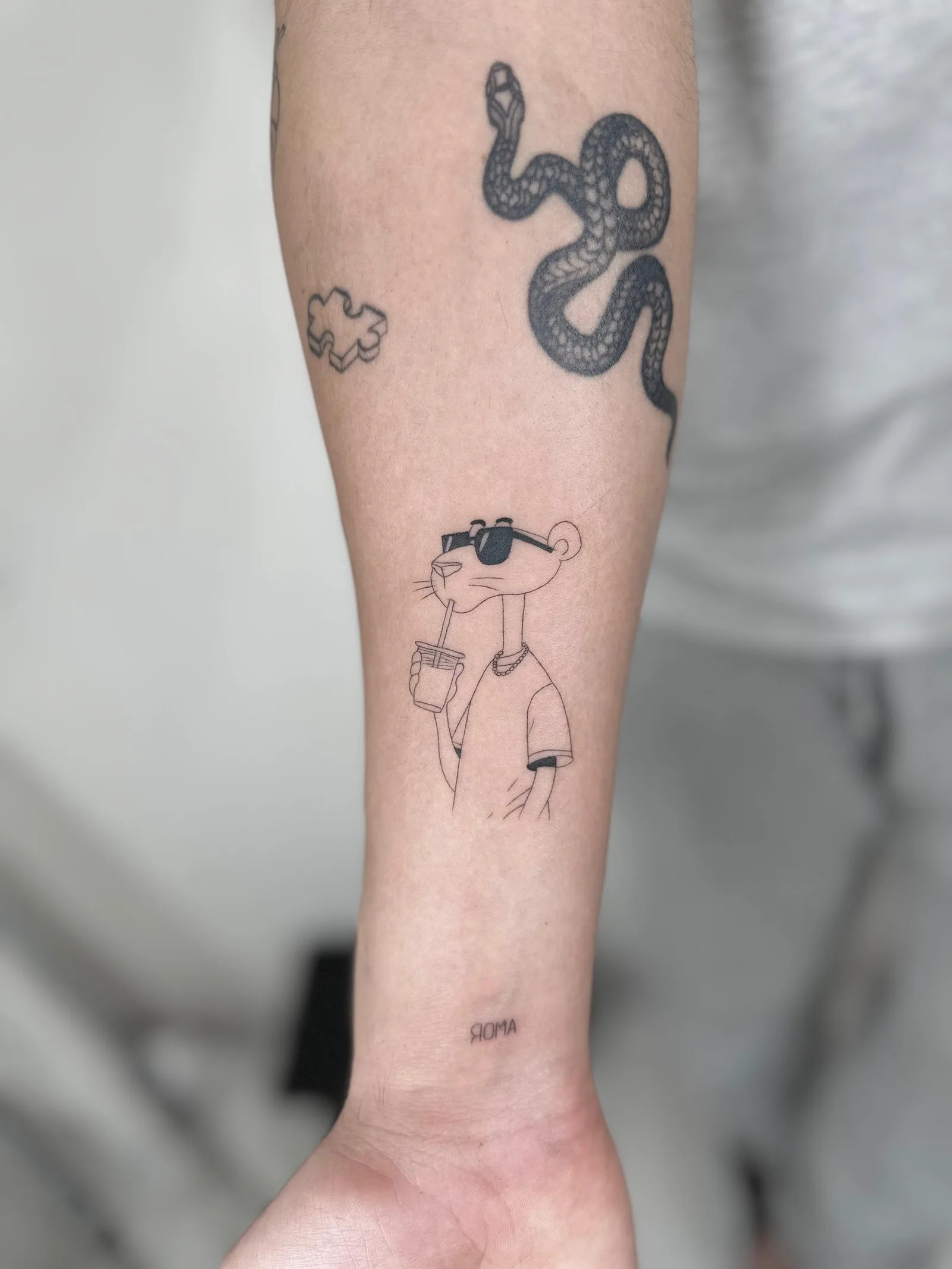 Tatuaje fineline en Madrid de la Pantera Rosa con gafas de sol y batido