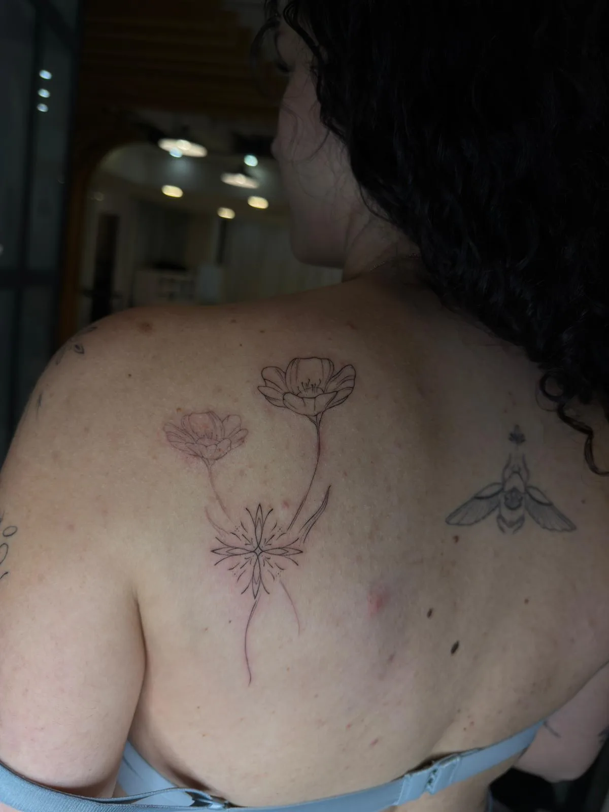 Ornamental tattoo with fine lines and solid black fills on the forearm