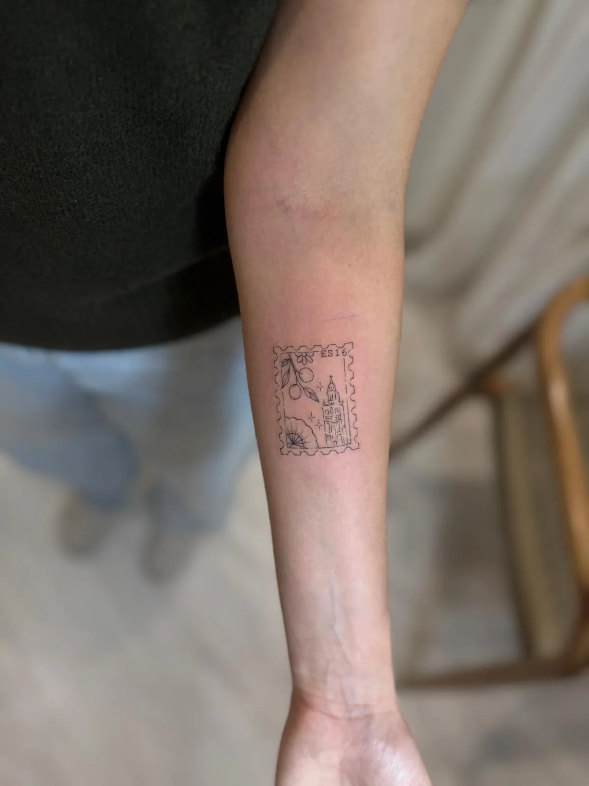 Rama de cerezo en flor tatuada en línea fina en el costado
