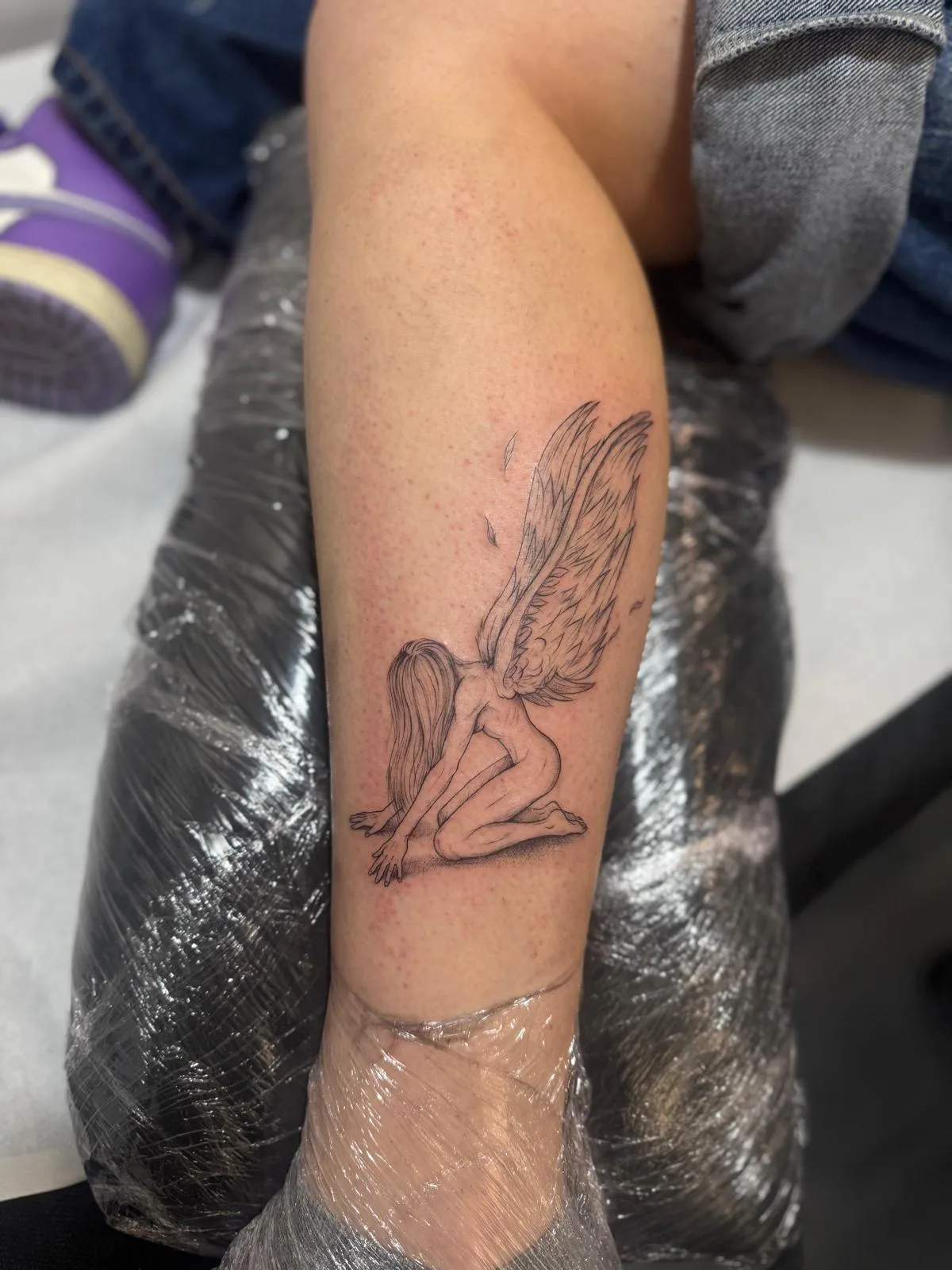 Frase corta en inglés con tipografía fina en el antebrazo