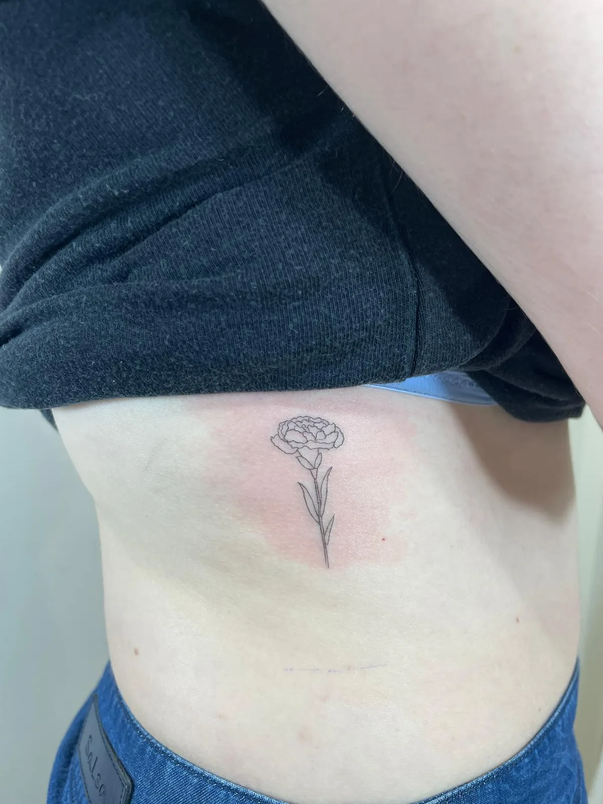 Luna menguante minimalista tatuada en tinta negra en la muñeca