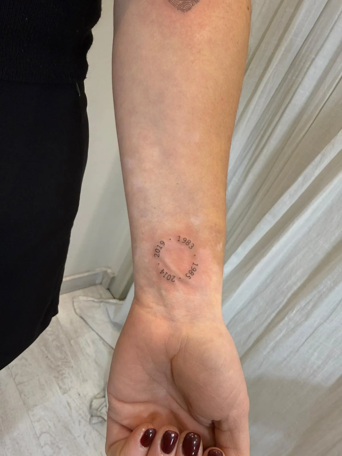 Pluma estilizada fine line con detalle de barbas sugeridas en el brazo