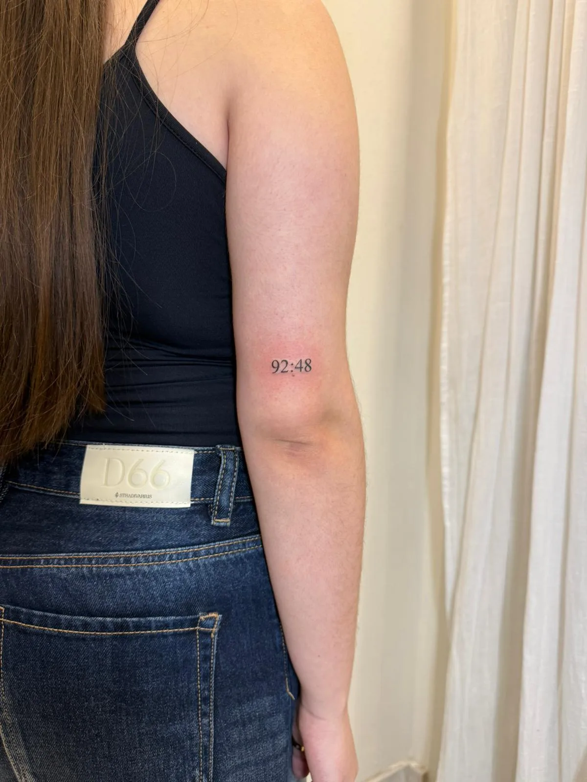 Ojo minimalista con pestañas sugeridas en línea fina en el antebrazo