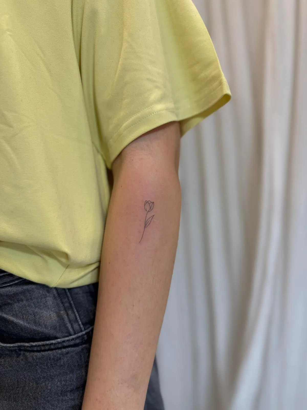Tulipán fine line con tallo delicado en la cadera