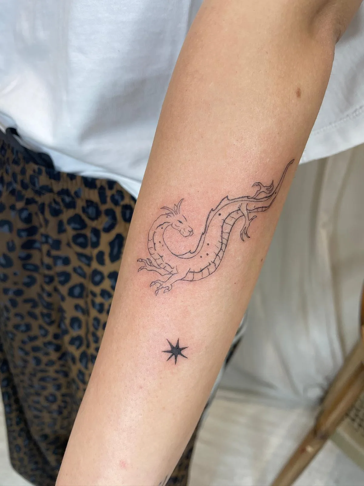 Vaso con rama botánica dentro en línea fina en el brazo