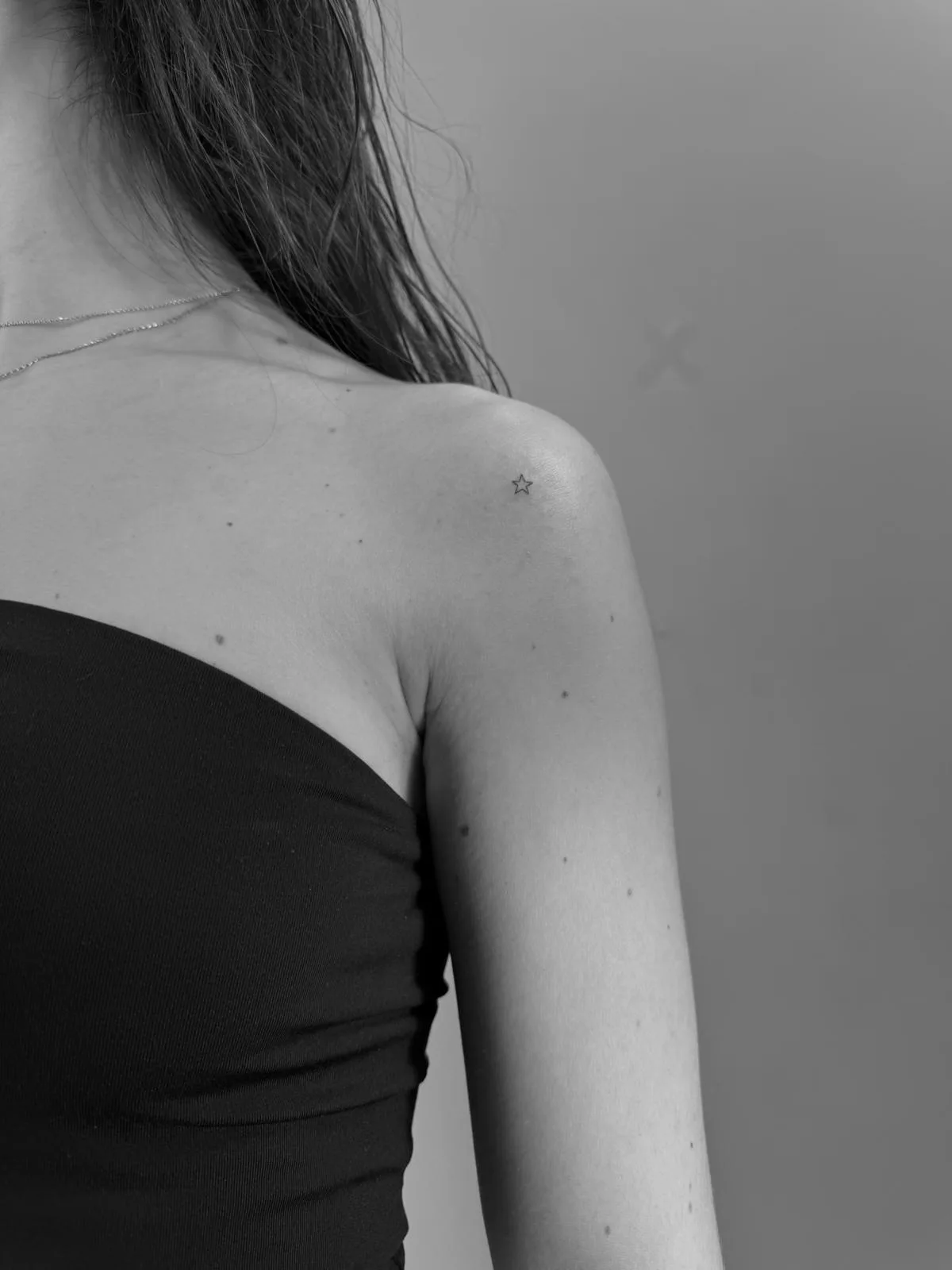 Tatuaje fineline en Madrid de estrella micro minimalista en trazo muy fino en el hombro